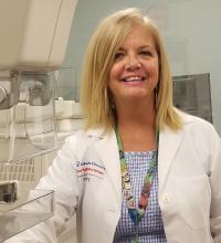 Mammography technician in front of mammography machine.
